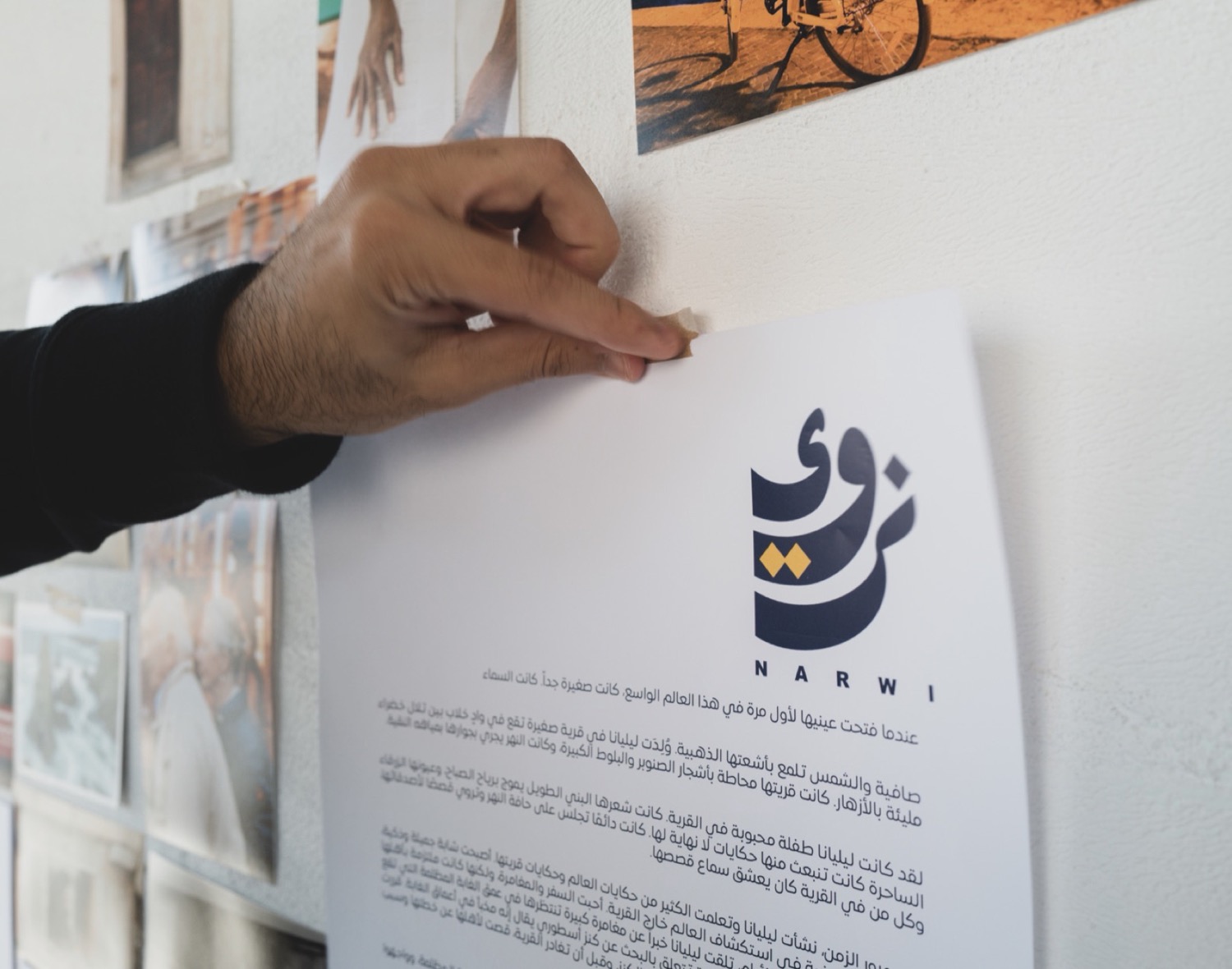 يدٌ تثبّت لقطات القصة على الجدار في غرفة المونتاج